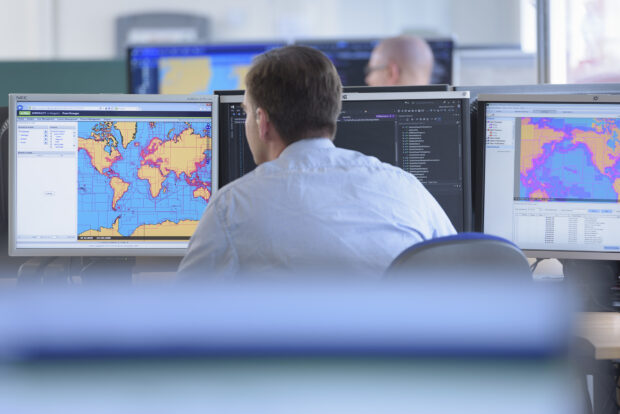 UKHO worker looking at code and geospatial data on a screen