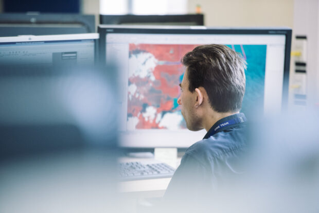 UKHO worker examining geospatial data on a computer screen