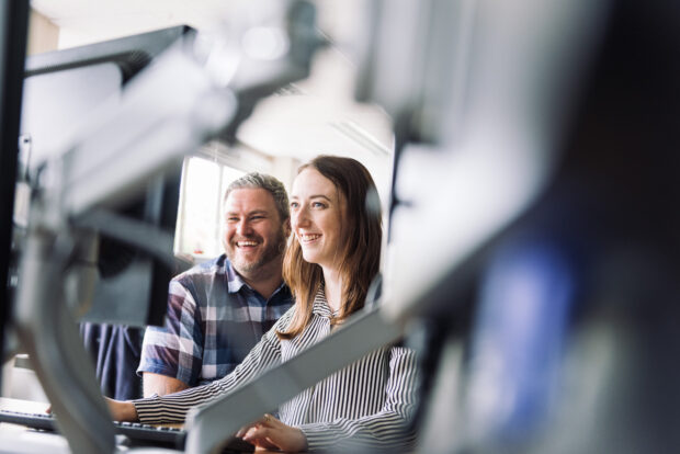 Two UKHO colleagues working collaboratively at a monitor