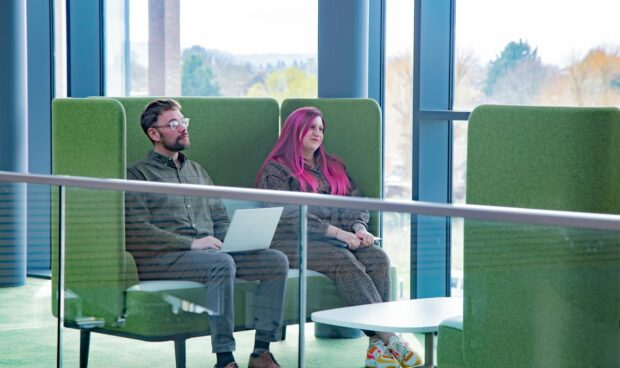 Two UKHO staff sat on sofas in breakout area of UKHO office