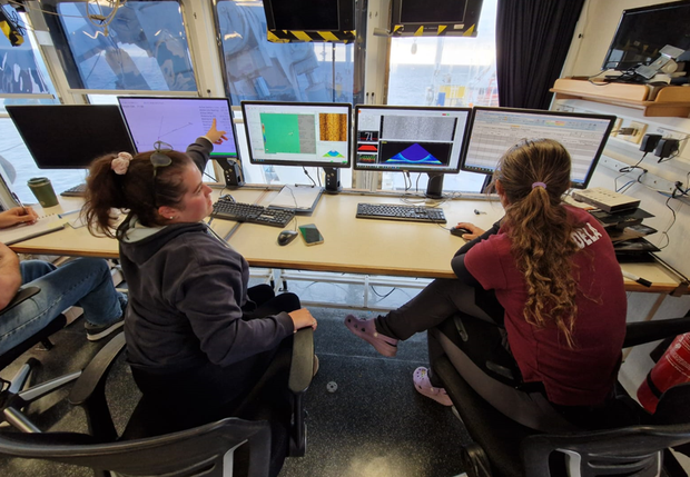 Two scientists reviewing multi-beam echosounder data on computer screens